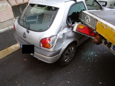 Náklaďák s přívěsem se nevešel na silnici a poškodil zaparkované auto