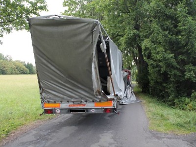 Řidič kamionu zachytil v aleji větev stromu a poškodil si přívěs