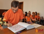Sbormistr Tomáš Pospíšil se podepisuje do kroniky