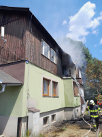 Zásah hasičů u požáru střechy a bytu řadového finského domku